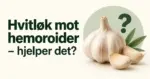En hel hvitløk og to hvitløksfedd ved et spørsmålstegn og teksten «Hvitløk mot hemoroider – hjelper det?» på lys bakgrunn.